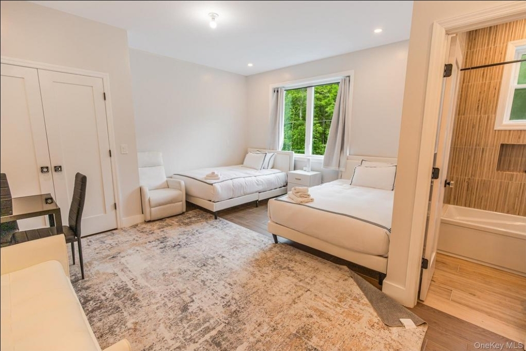 Spacious couple’s master suite with hardwood floors and bright natural light